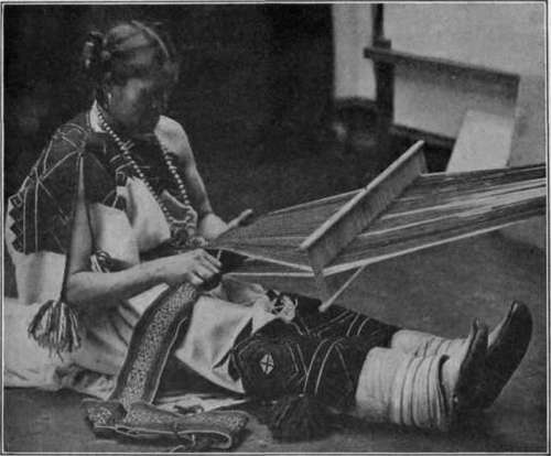 Fig. 43.   Indian girl weaving a belt by hand.
