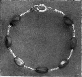 A BRACELET OF CATS' EYES AND ALUMINIUM BEADS.