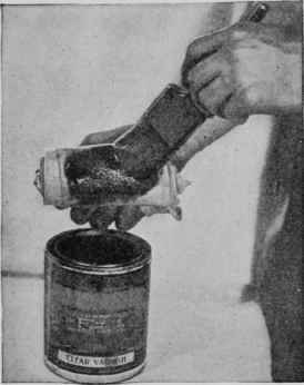 Applying clear varnish to a rubber made of cloth for use in a modified French polishing process.