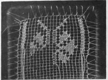 Detail of filet embroidery on hand made net