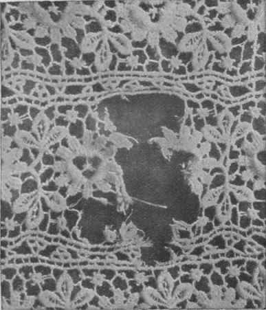 A tear in a piece of white thread lace that can be repaired by the ordinary needleworker