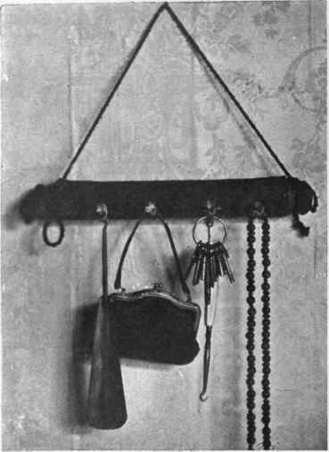 A useful tidy formed by covering a rolling pin with black velvet and furnishing it with cup hooks, from which may be hung such articles as button hook, purse, keys, or muff chain