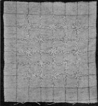 White flourishing thread is used to cover the lines of this glass cloth, stars and feather stitching making a good effect for bed spread squares