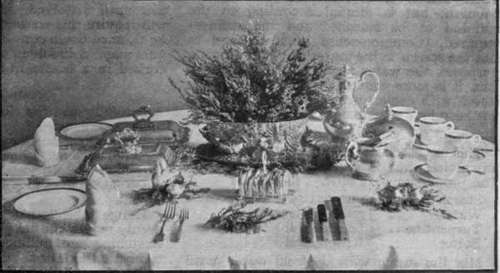 An autumn breakfast table decoration of purple heather, placed in a handsome game pie dish, resting on a bed of heather. A sprig of white heather is put by each plate