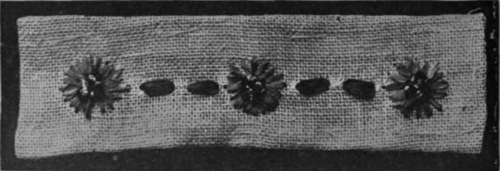 An odd strip of canvas worked in baby ribbon might be arranged as a serviette ring. Daisies, buttercups, and roses are quickly worked flowers