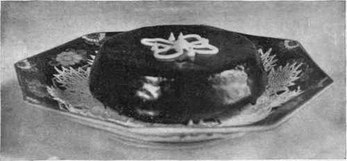 Cake Covered With Chocolate Icing And Ornamented In Center With Lines Of White Icing.