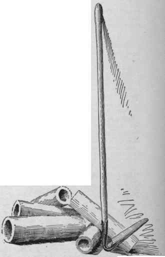 Common cylindrical drain tile; and a scoop for preparing the bed for the tile.