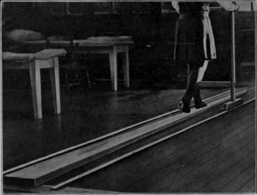 Fig. 117. Practising rocking on the walking board. The latter is a mere adaptation of a boom, and the trolley replaces a balancing pole
