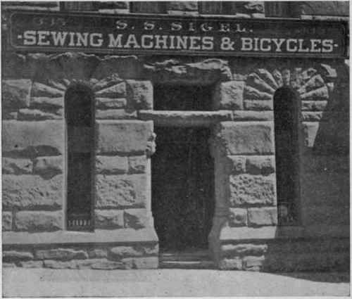 Equally massive, but steps omitted. Rents sacrificed. The dealer in sewing machines and bicycles can only exhibit six bottles of oil in each window to attract customers. Morrison and Seventh Streets, Portland, Ore.