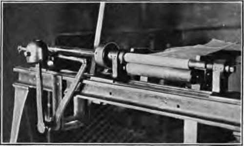 Case rolling machine; paper rolled on mandrel.